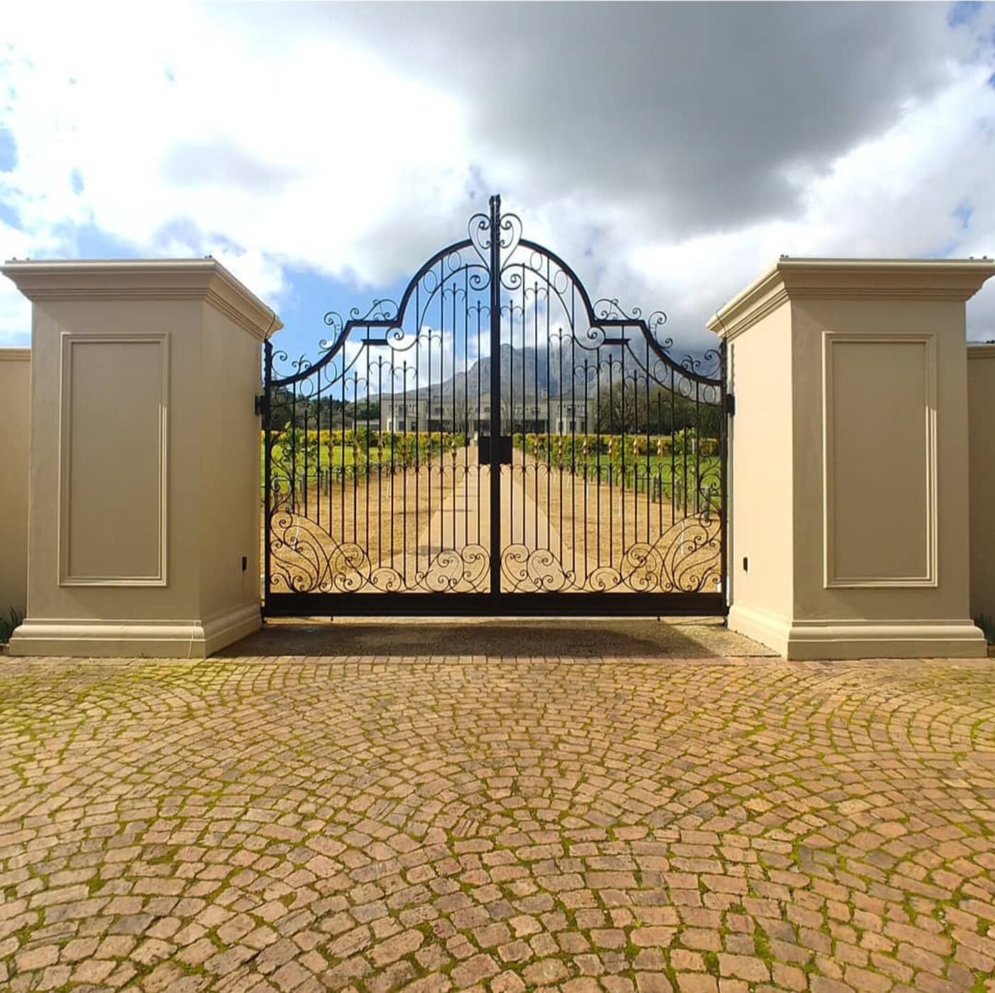Ornate wrought-iron estate driveway gate installed by Palmers Exclusive Gates